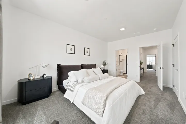 Recessed ceiling lighting, white walls, and gray carpeting