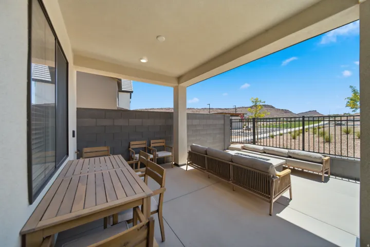 Covered patio featuring recessed lighting, a concrete floor, and a block fence
