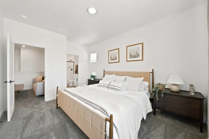 Plush carpet flooring, recessed ceiling lighting, white walls, and a separate room with a built-in shelf