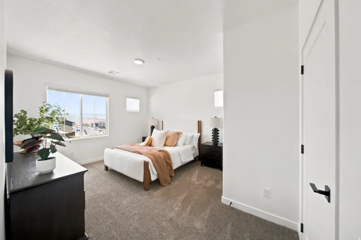 Carpeted room with white walls, a large window, and recessed lighting