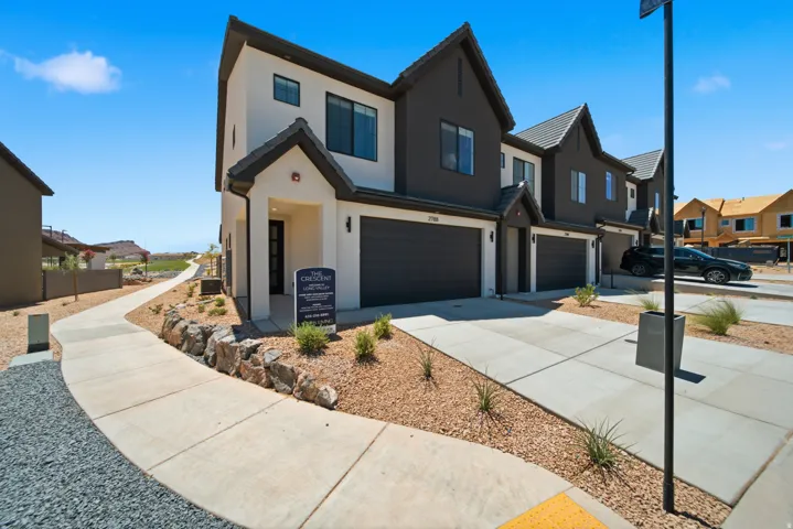 Modern two-story exterior with a contrasting façade, attached garage, concrete driveway, and a paved walkway