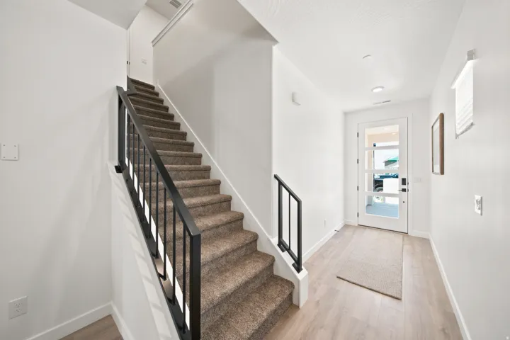 Modern entry featuring light wood-finish flooring, a contemporary front door with multiple glass panels, and recessed ceiling lighting