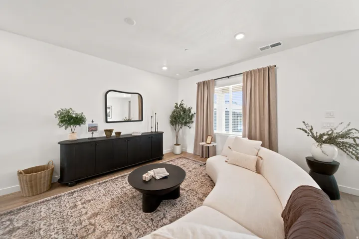 Recessed ceiling lighting, wood-finish flooring, white walls, and a window with blinds