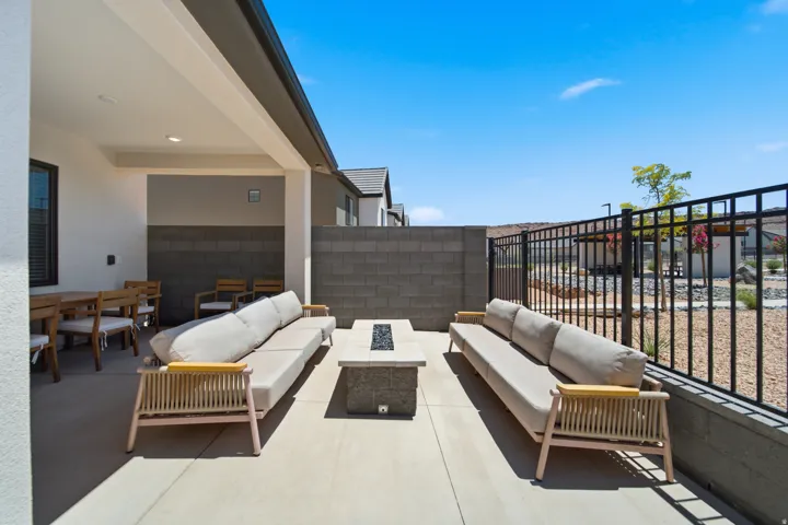 Spacious covered patio with concrete flooring, recessed lighting, and a built-in fire pit