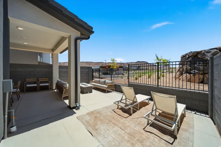 Covered patio featuring recessed lighting, a concrete slab, and a low-maintenance yard with a metal fence