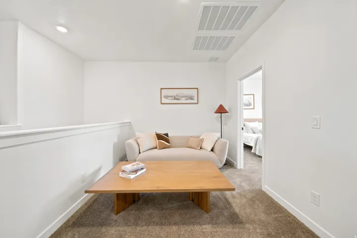 Carpeted loft area with recessed lighting, an open railing, and white walls