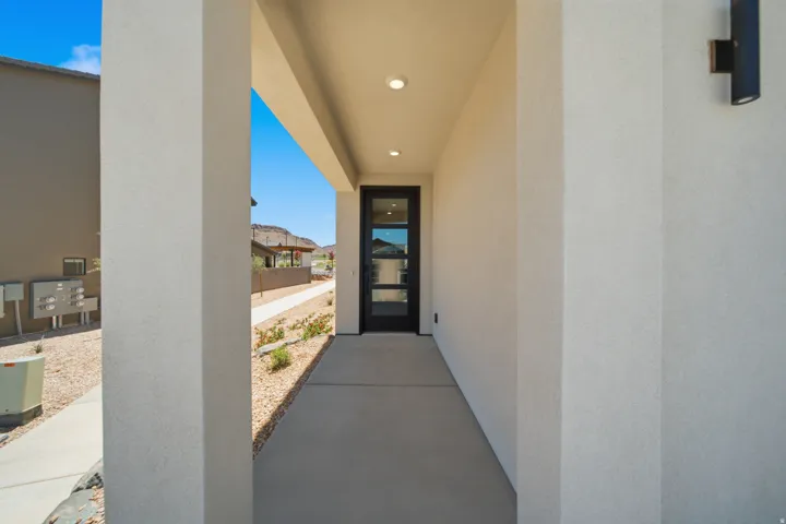 Recessed entryway featuring stucco exterior, a black frame glass panel door, and integrated ceiling lighting
