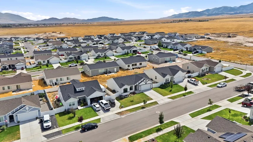 Expansive residential development featuring modern single-story homes, uniform landscaping, and paved streets