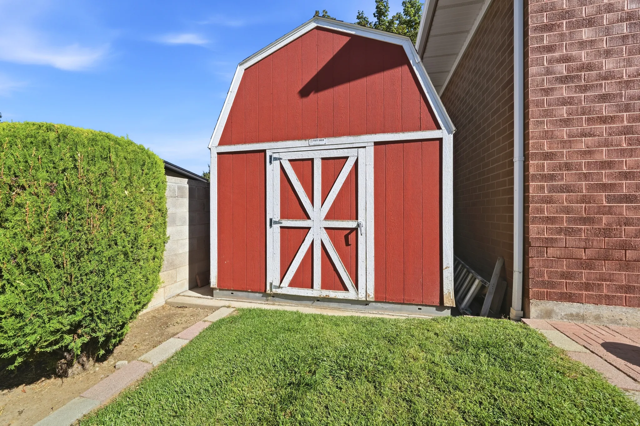 Red storage shed with white trim and barn-style doors