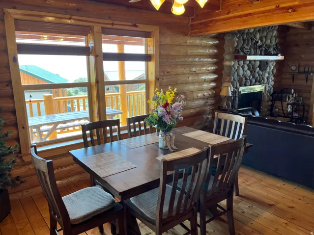 Dining area featuring warm wood-finish flooring and log walls
