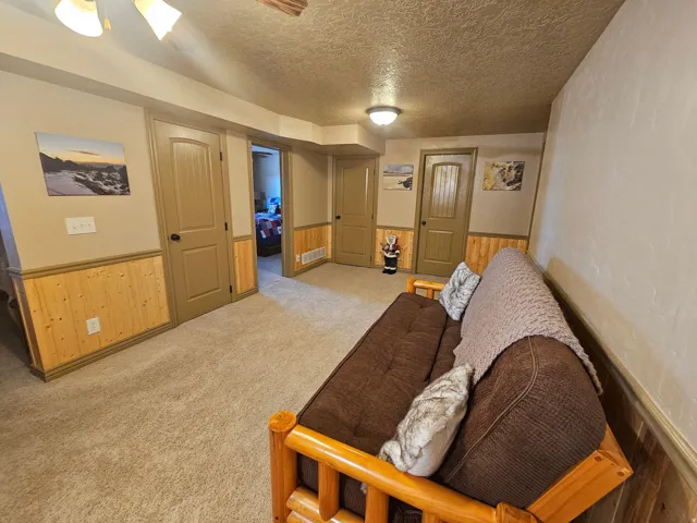 Carpeted flooring with painted walls and wood paneling