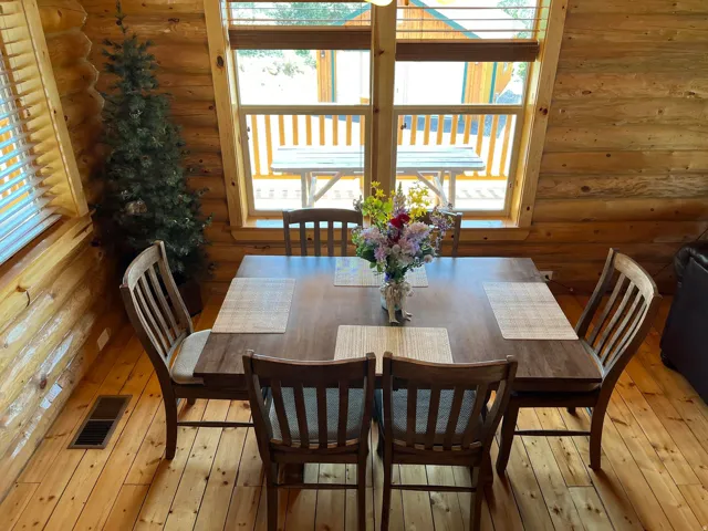Wood-paneled walls, natural wood-finish flooring, and a large window with wood blinds