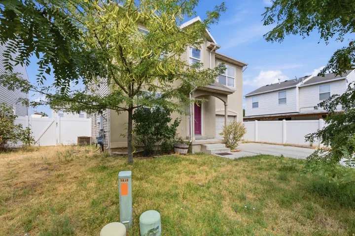 Two-story stucco exterior with an arched entry, a prominent front door, and an attached garage