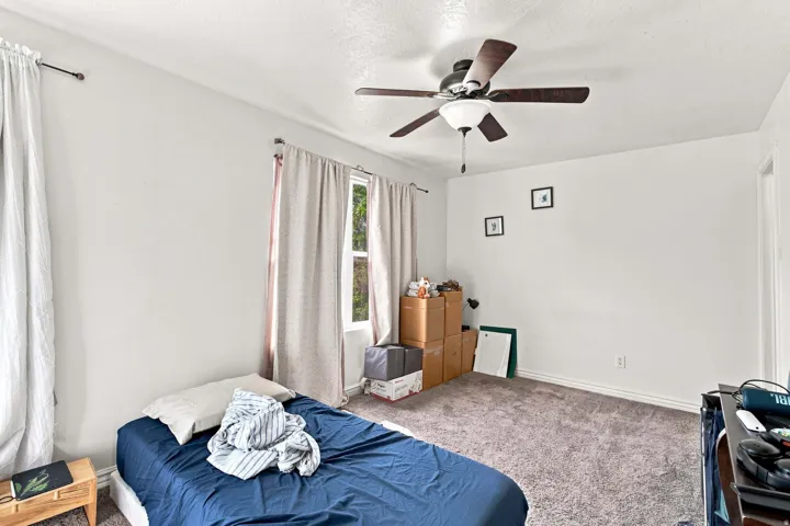 Carpeted flooring, white walls, and a ceiling fan with integrated lighting