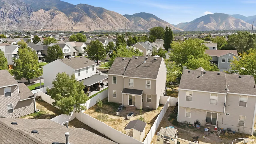 Mountain backdrop, residential neighborhood setting, fenced backyard, exterior siding, multiple rooflines