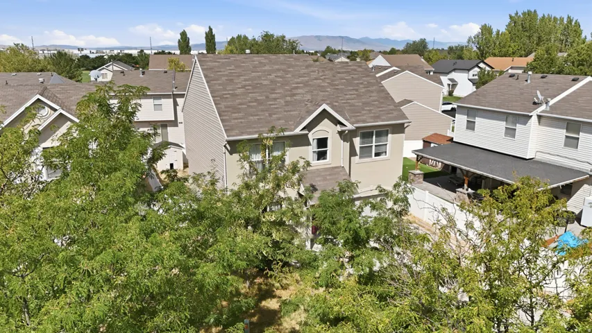Two-story residence with a pitched shingle roof, neutral-toned siding, and multiple windows