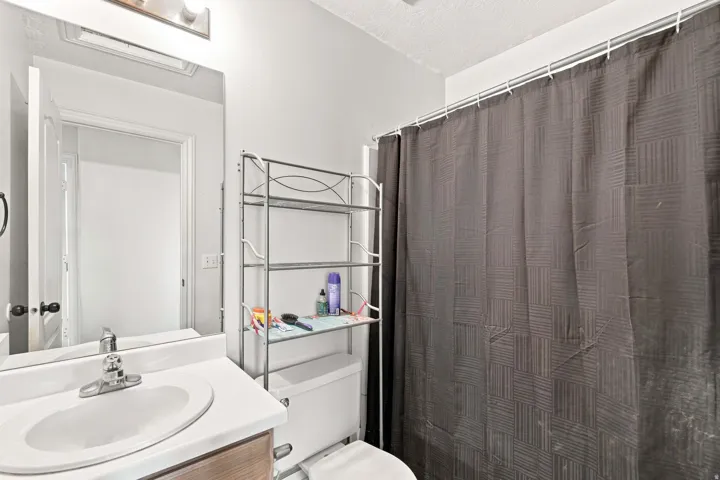 White vanity with a single basin sink and chrome faucet