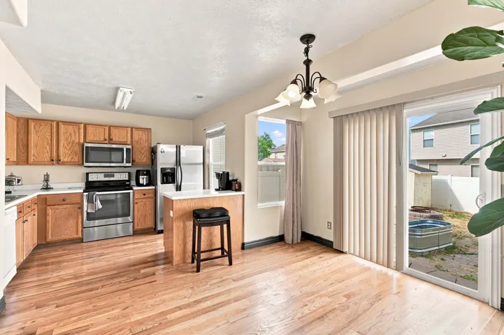 Kitchen with wood-finish flooring, stainless steel appliances, and a breakfast bar
