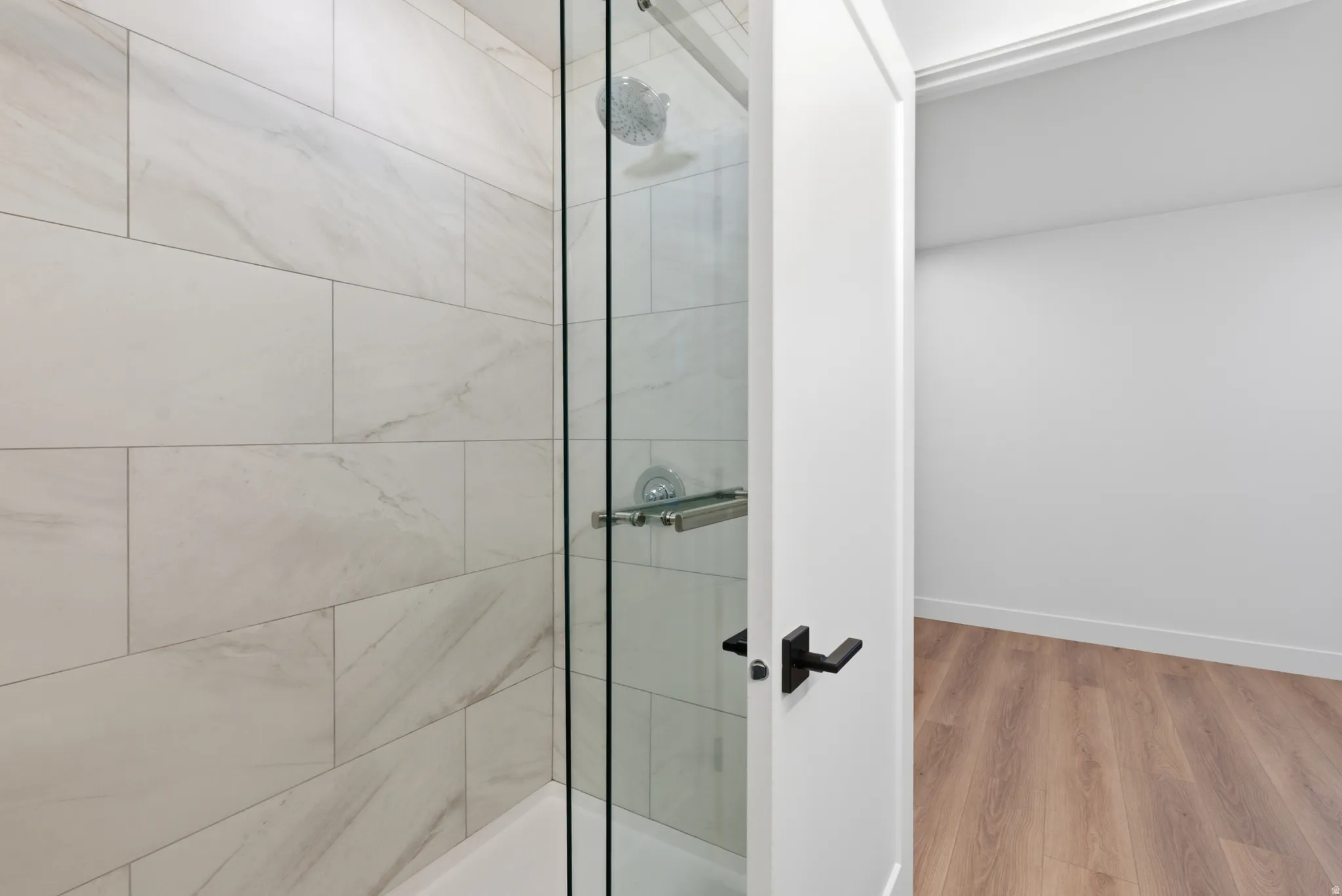 Shower with full-height subway tile surround, clear glass enclosure, and chrome fixtures
