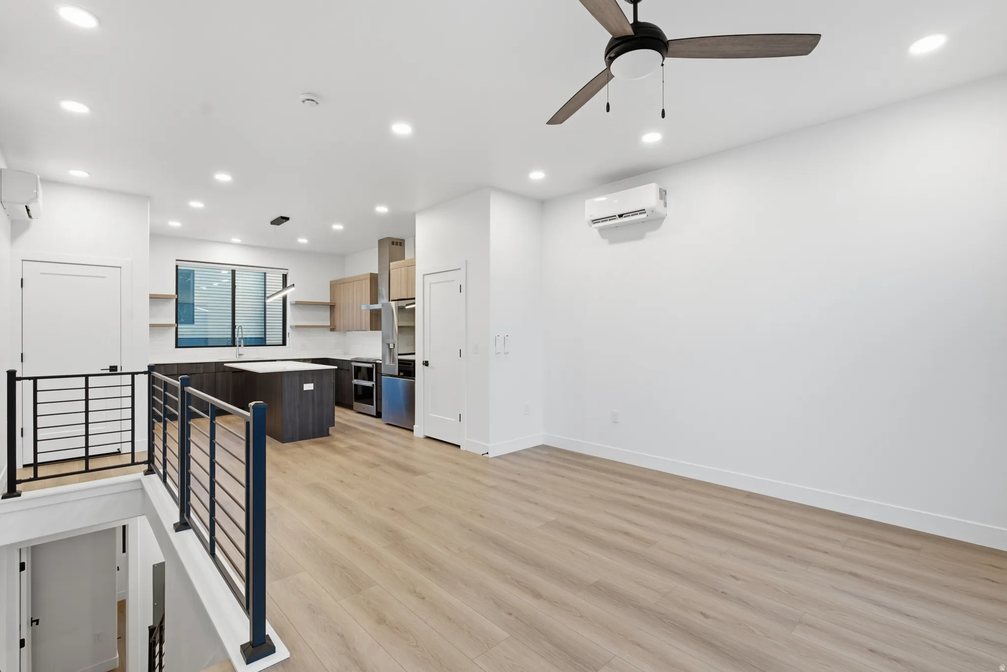 Open-concept living space featuring LVP flooring, recessed lighting, and a ceiling fan