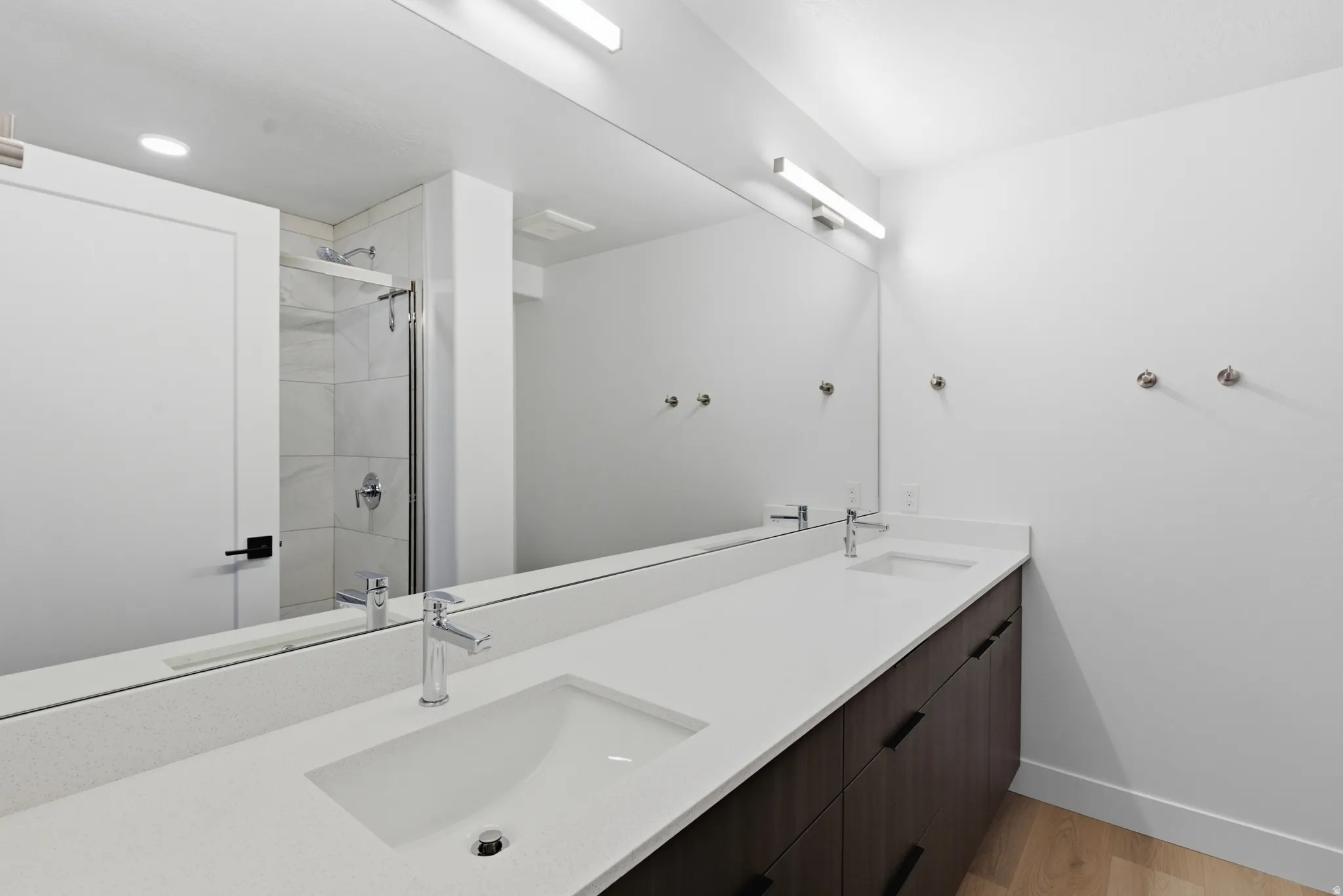 Dual vanity with integrated rectangular sinks, white stone-finish countertop, and dark wood-finish cabinetry