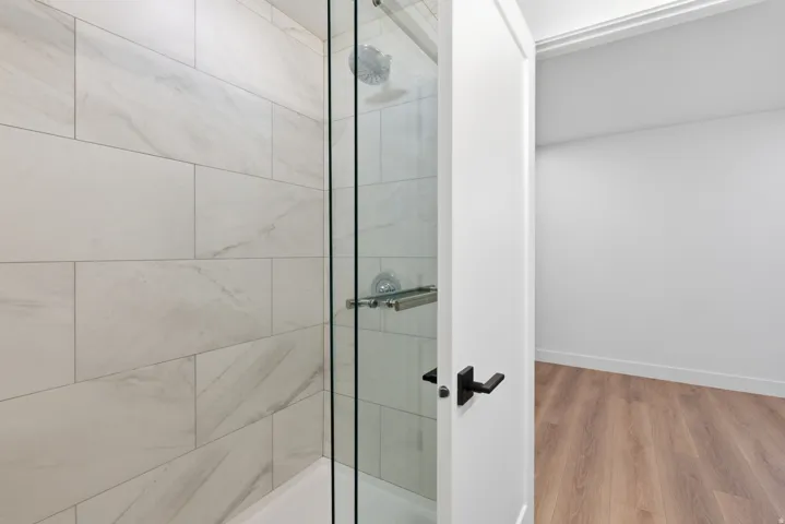 Shower with full-height subway tile surround, clear glass enclosure, and chrome fixtures