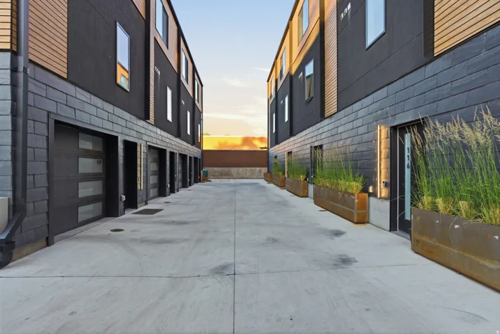 Concrete driveway with multiple modern garage doors featuring frosted glass panels