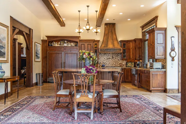 Kitchen featuring wood-finish cabinetry, a large wood-finish range hood, and a mosaic tile backsplash