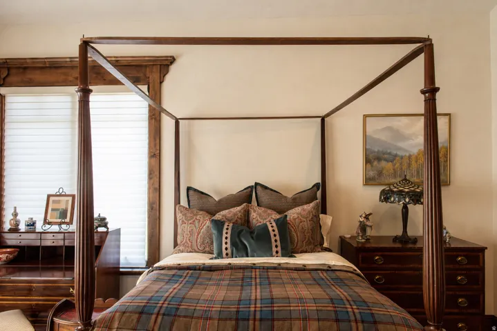 Wood window trim, white horizontal blinds, and a built-in wood desk