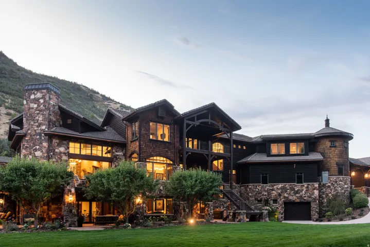 Stunning stone and wood-finish exterior with multiple levels, expansive glazing throughout, and architectural detailing