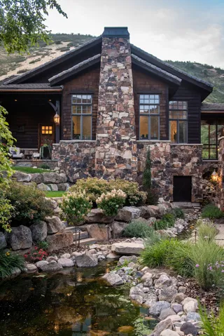 Stone and wood-sided exterior featuring a prominent stone chimney
