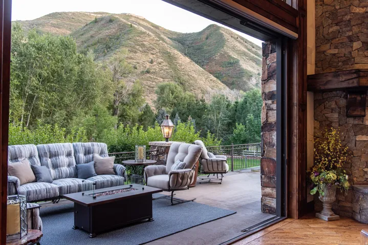 Seamless indoor-outdoor living with expansive composite decking, custom black fire table, and built-in seating