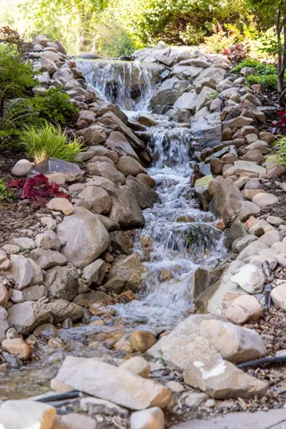 Tiered rock waterfall with natural landscaping