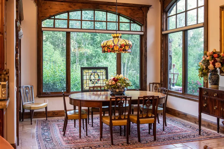 Expansive window wall with arched transom windows, rich wood-finish trim, and tile flooring