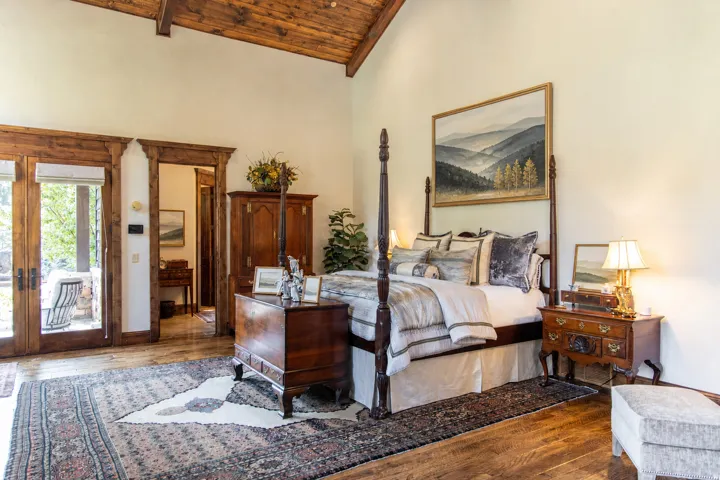 Vaulted wood-paneled ceiling with exposed beams, wood-finish flooring, and French doors