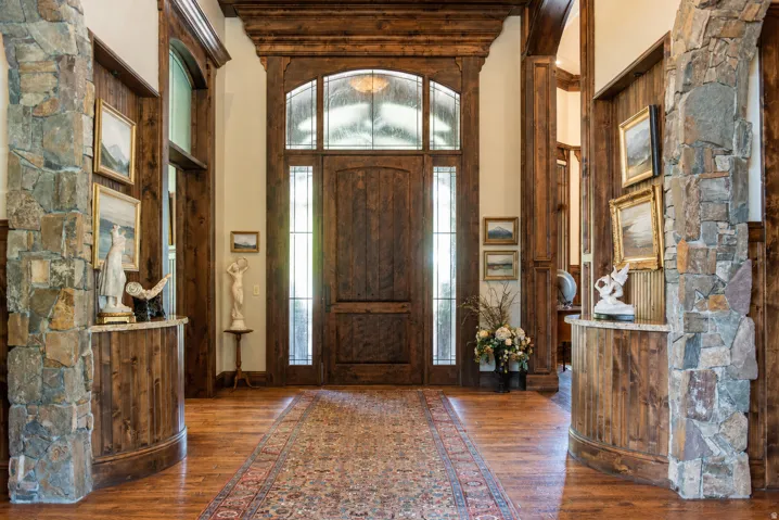 Grand entry with a wood-finish door, transom window, and sidelights