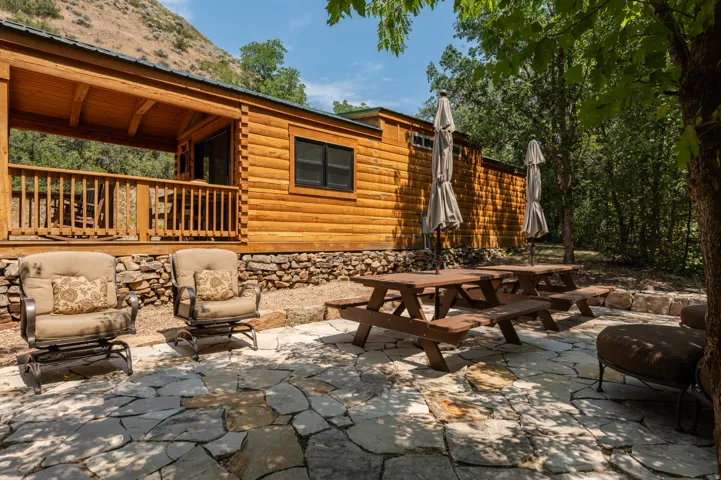 Log cabin exterior with a covered porch and flagstone patio