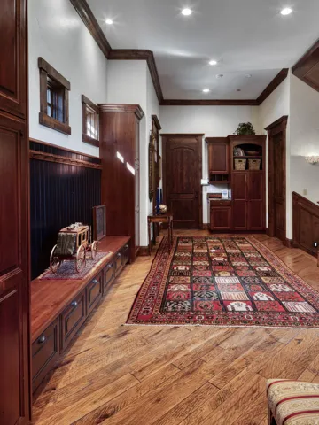 Hallway featuring wood-finish flooring, built-in cabinetry, and recessed lighting