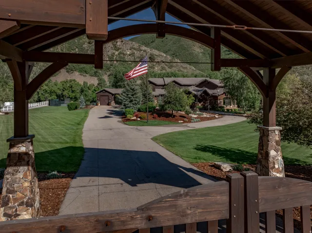 Expansive circular driveway leading to a residence with a multi-gabled roofline