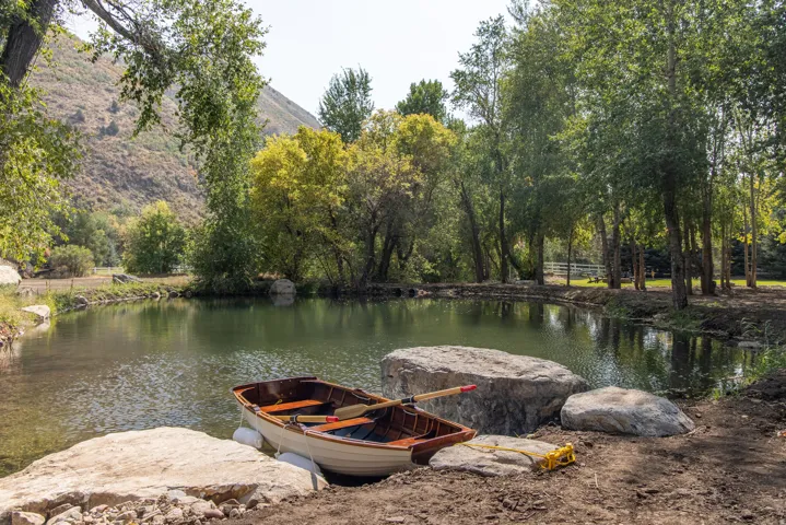 Serene private pond with clear water and a natural, rocky shoreline
