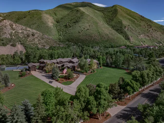 Expansive estate featuring a large main residence, a private tennis court, and a multi-car garage