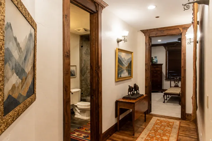 Hardwood flooring, recessed lighting, and decorative wall sconces