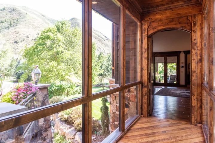 Wood-paneled hallway with arched doorway and wood-finish flooring