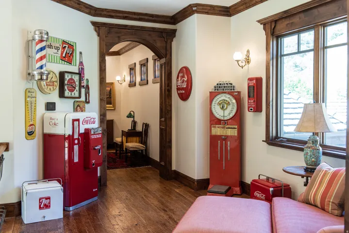 Wood-finish flooring, dark wood trim, arched doorway, and built-in wall sconces