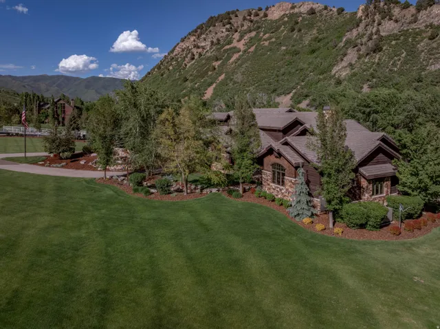 Expansive property featuring a stone and wood-sided residence with multiple gables