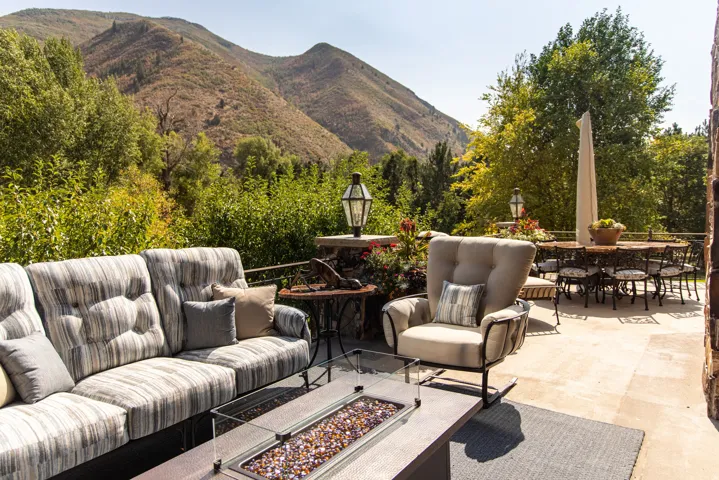 Expansive outdoor patio featuring a stone surface, built-in fire pit, and stone retaining wall