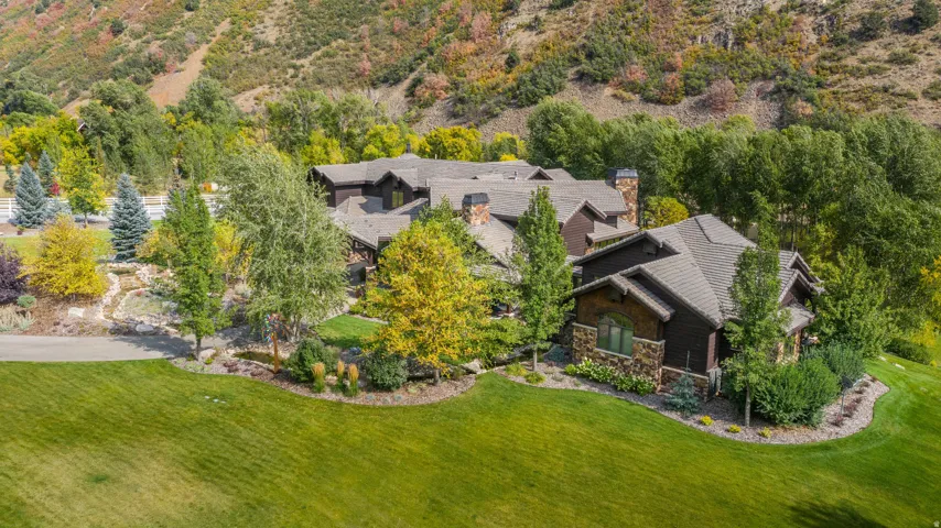 Expansive green lawn with mature landscaping and established trees
