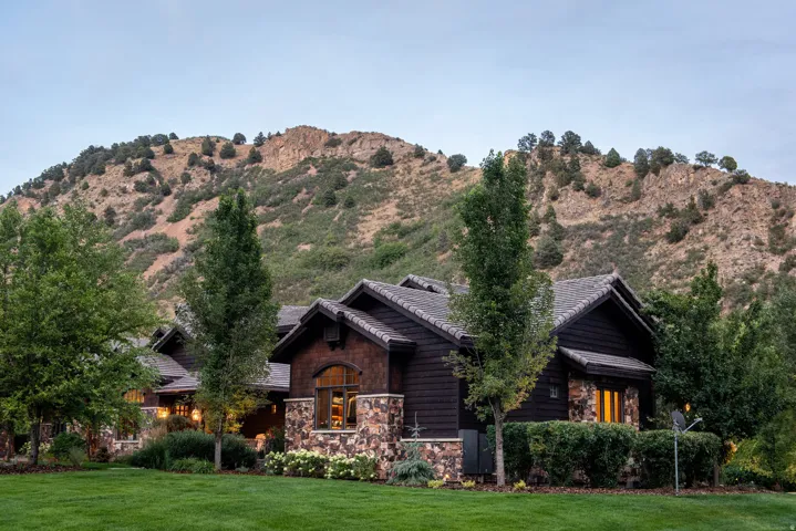 Stone and wood shingle exterior with a mountain backdrop