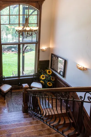 Staircase featuring wood-finish treads, decorative wrought iron balusters, and a wood-finish handrail