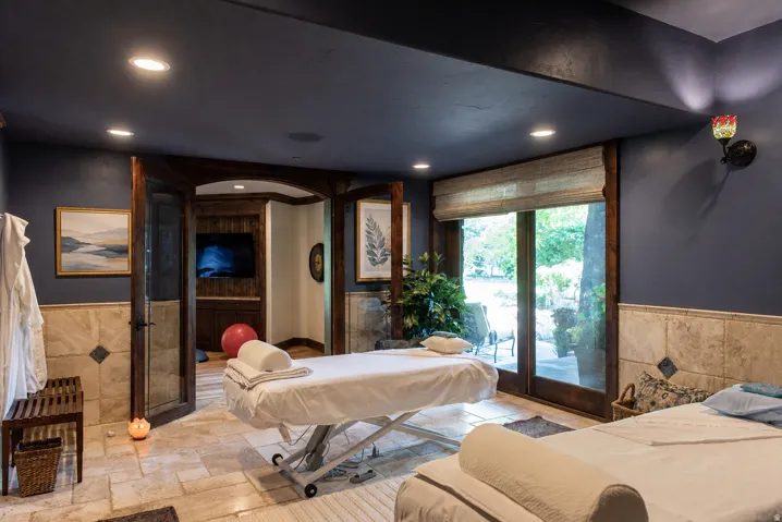 Stone-tiled flooring, recessed lighting, and a built-in media center with wood paneling